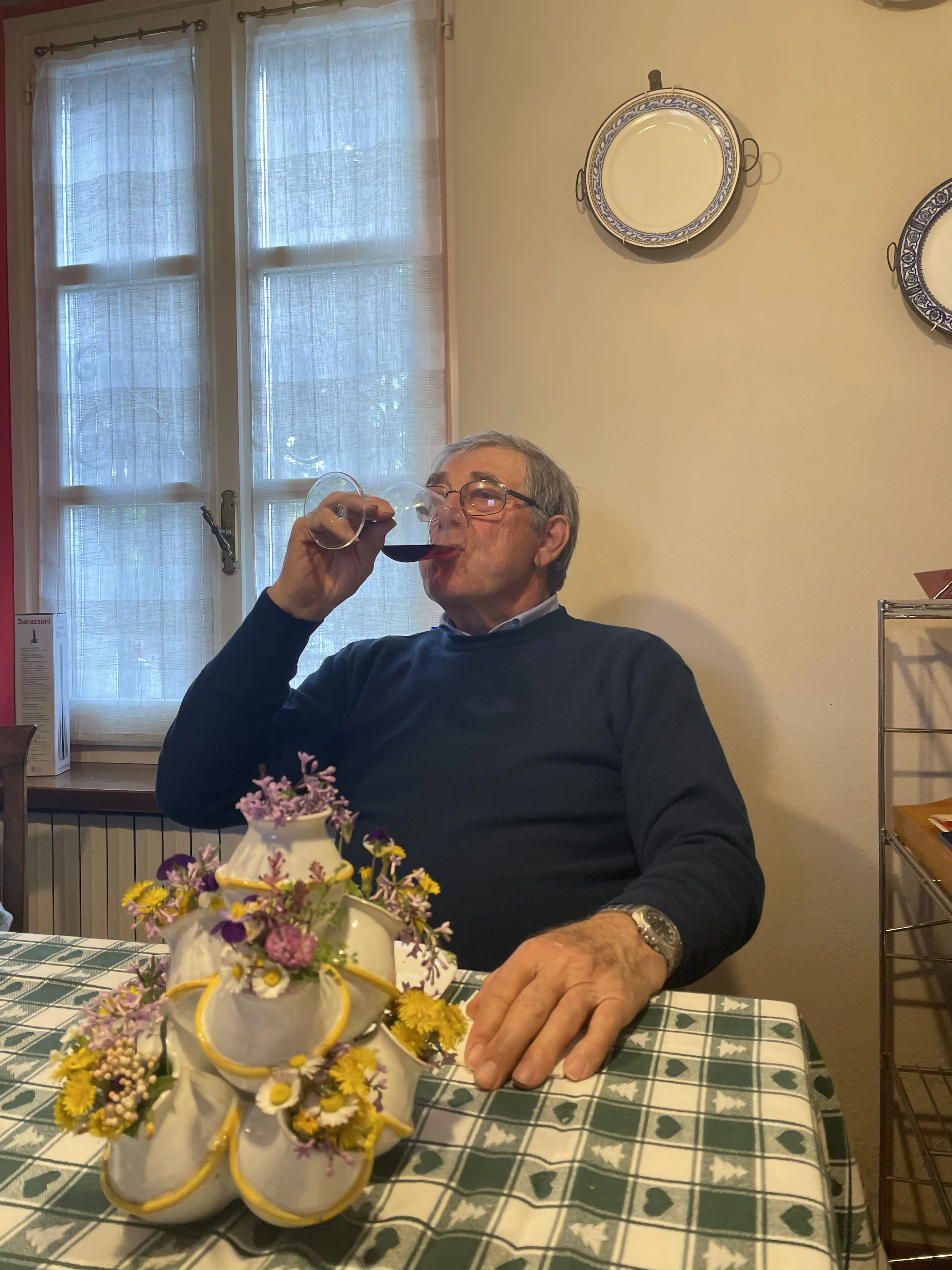 Luigino degusta il vino dell'azienda vitivinicola di famiglia, a tavola