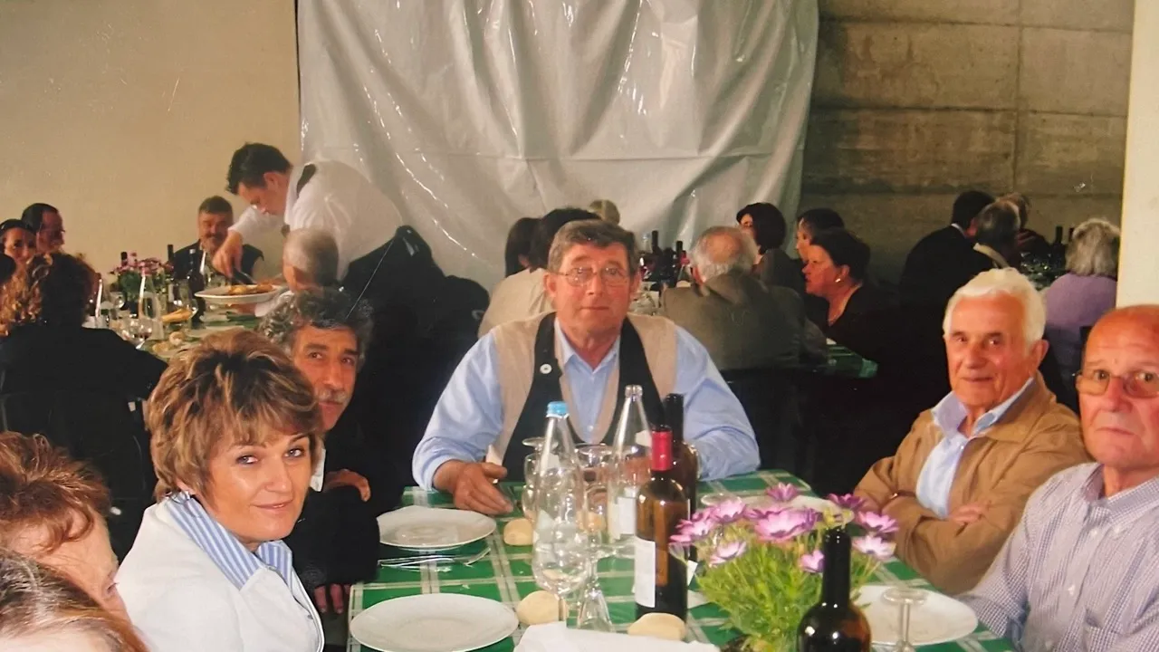 Luigino Capra al suo tavolo, che parla e beve con i suoi clienti durante il pranzo del primo maggio, nell'azienda vitivinicola Michele Capra, tra le colline del Monferrato astigiano, a Repergo, Isola d'asti
