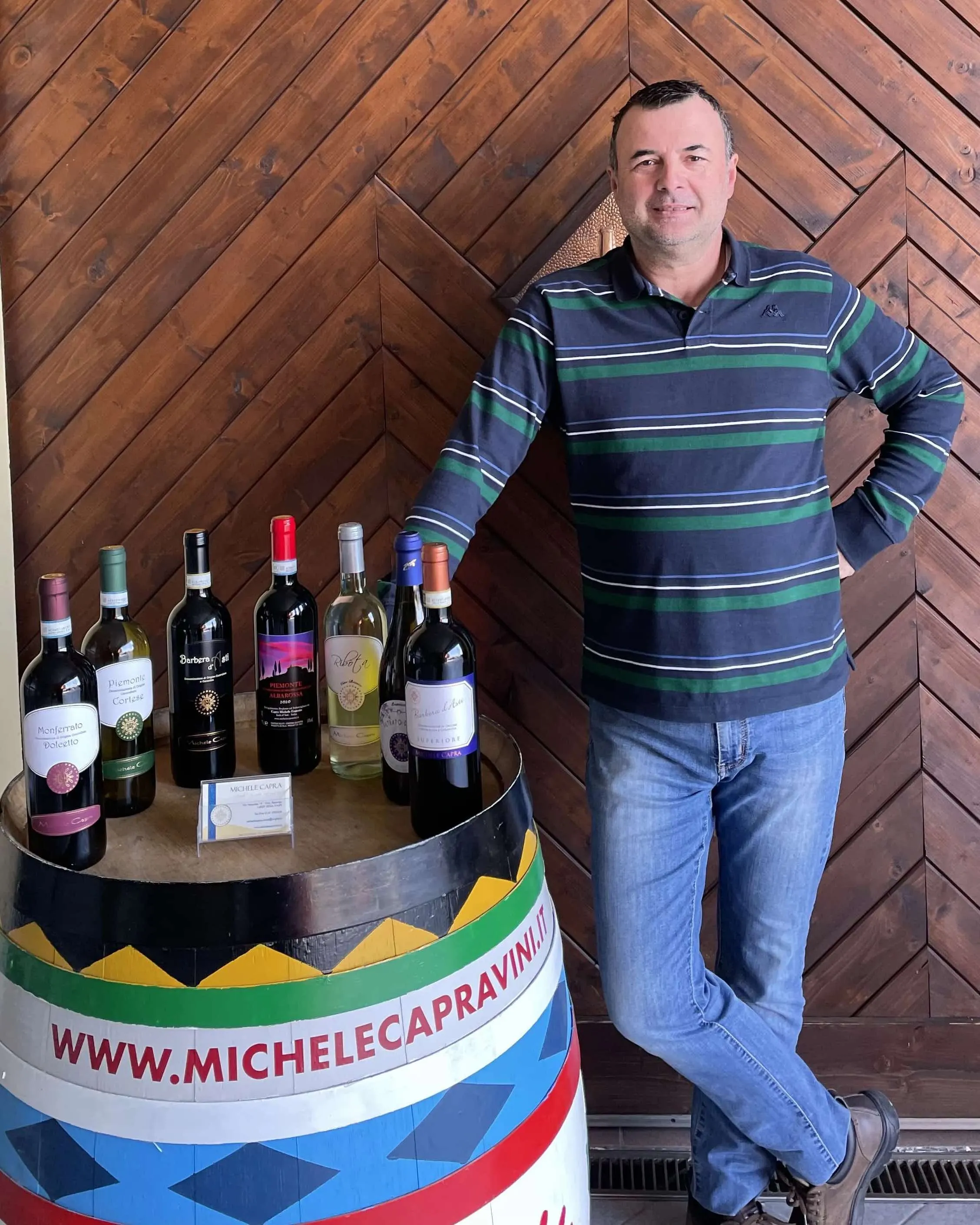 Michele Capra e le sue varietà di vino disposte su una botte dipinta