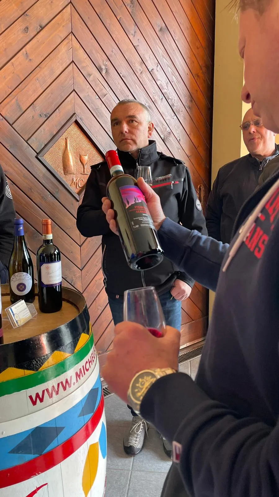 Cliente di Michele Capra osserva e ispeziona una bottiglia di Piemonte Albarossa